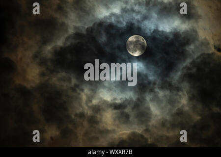 Full moon in cloudy night sky Stock Photo
