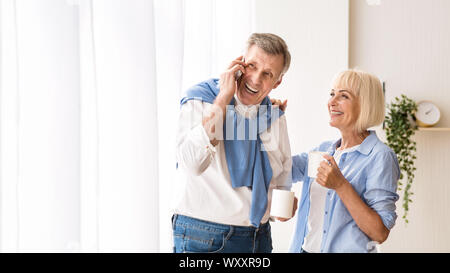 Happy mature man talking on phone, drinking tea Stock Photo