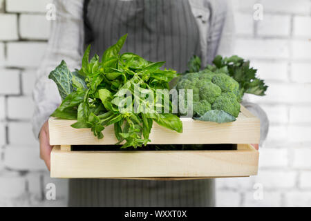 Woman holding Organic and eco green vegetables inside box Stock Photo