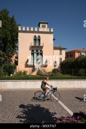 cyclist riding on the promenade at Bardolino Lake Garda Italy Stock Photo