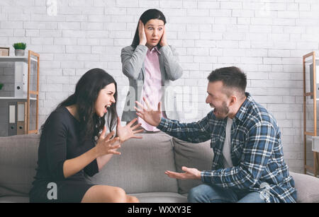 Young aggressive couple shouting at marital therapy Stock Photo