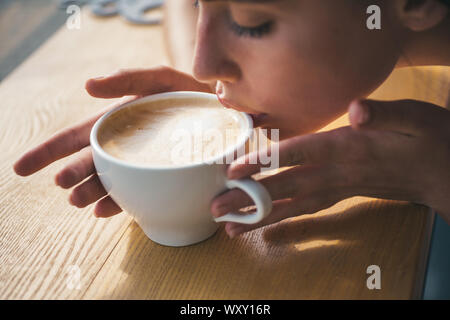 relax in cafe or coffee shop and drinking. perfect morning. Enjoying her morning. girl smell aroma coffee cup. fresh morning coffee with milk and Stock Photo