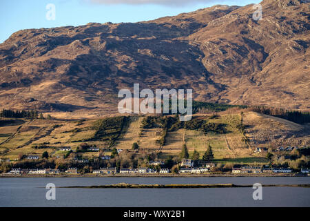 Looking across Loch Carron from Attadale in late afternoon light detailing the strips of croft land behind Lochcarron village with common grazing. Stock Photo