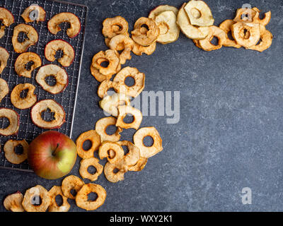 Dried slices of red and yellow apples, and fresh apple Stock Photo