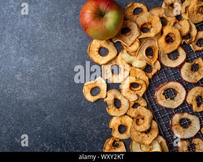 Dried slices of red and yellow apples, and fresh apple Stock Photo