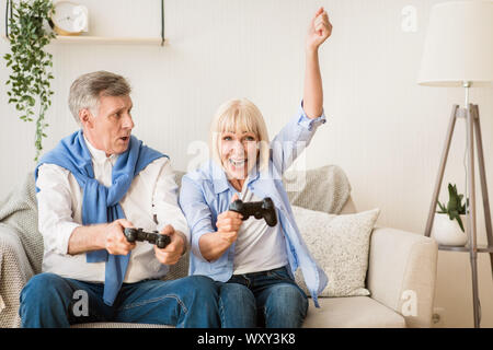 Senior couple having great time, playing video games Stock Photo