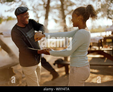 Young couple holding hands while dancing playfully together. Stock Photo
