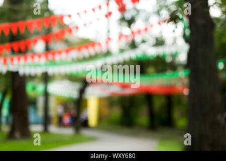 Party concept outdoor in city park with bright ribbon on trees Stock Photo