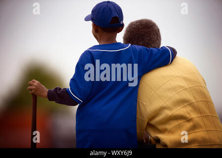 View of a small boy standing next to a man. Stock Photo