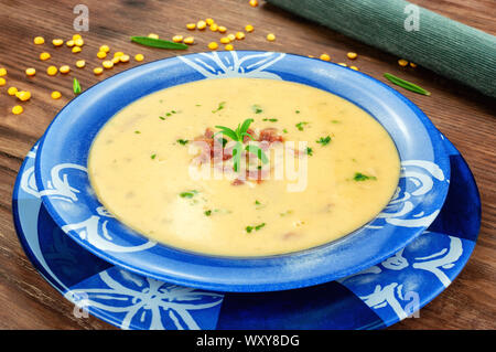 Yellow split pea cream soup with bacon and basil Stock Photo