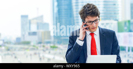 panoramic view on dynamic young executive calling outside, free of any constraint. Symbolizing a job search or a trade of outsourcing Stock Photo