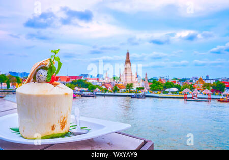 The unique dessert in coconut with fruits, ice cream and pieces of coconut pulp inside, on the supper in Bangkok, Thailand Stock Photo