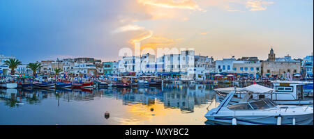 BIZERTE, TUNISIA - SEPTEMBER 4, 2015: Panorama of port with many moored fishing boats, cafes and vintage edifices on cloudy sunset, on September 4 in Stock Photo