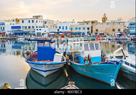 BIZERTE, TUNISIA - SEPTEMBER 4, 2015: The moored boats in old port with busy old town quarter on the background, on September 4 in Bizerte Stock Photo