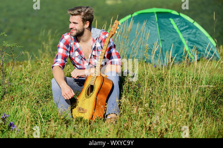 Musician looking for inspiration. Summer vacation highlands nature. Dreamy wanderer. Pleasant time alone. Peaceful mood. Guy with guitar contemplate nature. Wanderlust concept. Inspiring nature. Stock Photo
