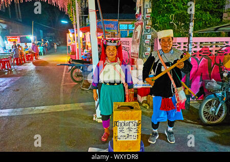 PAI, THAILAND - MAY 5, 2019: The couple of senior members of Lisu Hill Tribe in traditional costumes sings and dances, playing tseubeu banjo-like musi Stock Photo