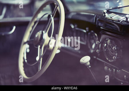 Close-up of the cockpit of a vintage car showing steering wheel and gear Stock Photo