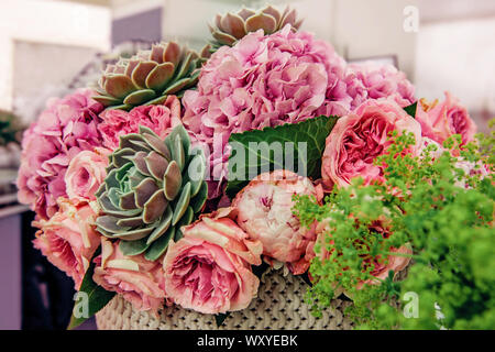 Beautiful bouquet of pink peony roses with exotic succulents roses. Trends in modern floristry. Selective focus Stock Photo