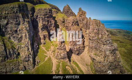 The dramatic vertical pillars of rocks agaings the blue sea under the clear sky on Isle of Skye Stock Photo