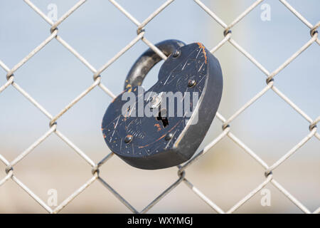 Heart shaped lock on chain link fence to symbolize committed relationship Stock Photo