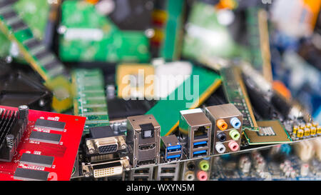 Assorted connectors on a computer mainboard detail on an blurry e-waste pile. Used or obsolete electronic components and PC parts in background. Eco. Stock Photo