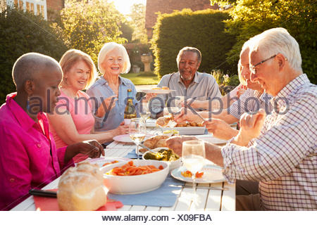 Group Of Senior Friends Enjoying Outdoor Dinner Party At Home