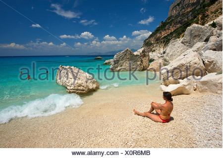 Italy, Sardinia, Person lying on beach, sandy feet Stock Photo