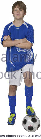 Junge steht mit einem Bein auf Fussball, verschraenkte Arme (model-released)