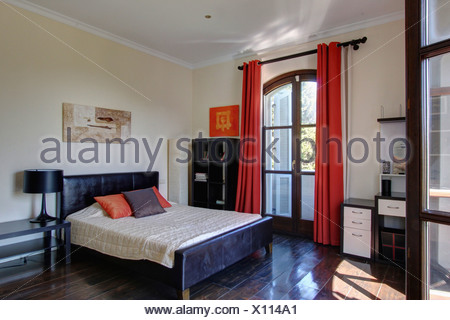 Red Curtains On French Windows In Spanish Bedroom With Black