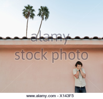 Man covering his face outdoors