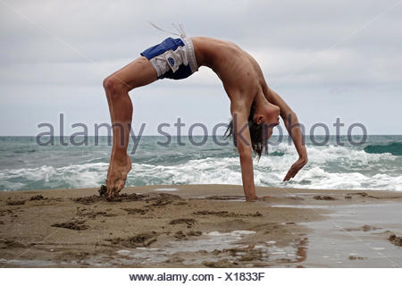 Noto, Italy, boy doing on the beach of Calamosche a handstand Stock ...