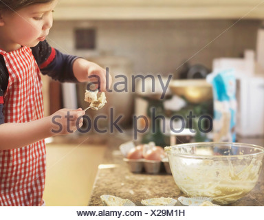 Child holding spoon with cake mix