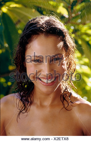 female long wavy wet brunette hair standing in rain water droplets running down chest looking to camera smiling showing