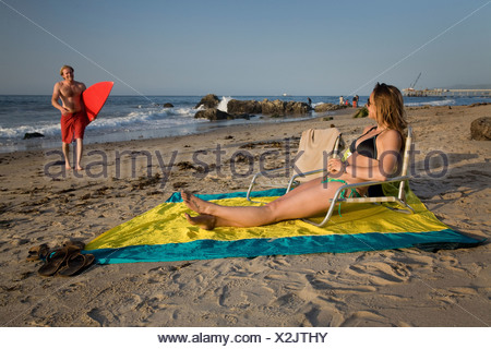 Young couple in swimwear walking at beach. Multiethnic ...