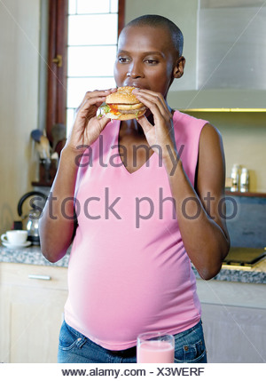 Pregnant woman eating a burger Studio Shot