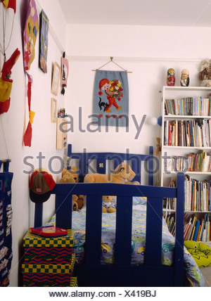 Fabric Wall Hanging Above Blue Wooden Bed In Child S Bedroom