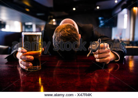 Drunk man holding a beer and car keys