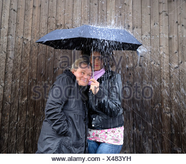 Two women under one umbrella