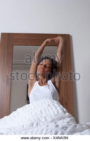 Woman stretching in bed