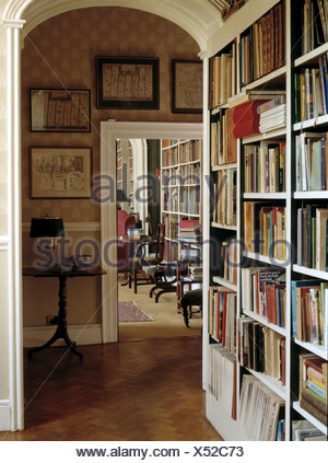 Fitted Bookcase In Country Hall With Open Door To Study Stock