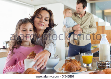 https://l450v.alamy.com/450v/x54bb6/girl-having-breakfast-beside-her-mother-at-a-kitchen-counter-x54bb6.jpg