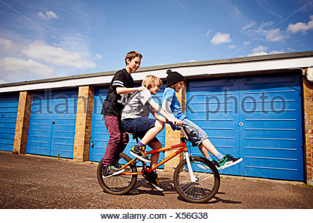 Boy giving two friends a ride on bike