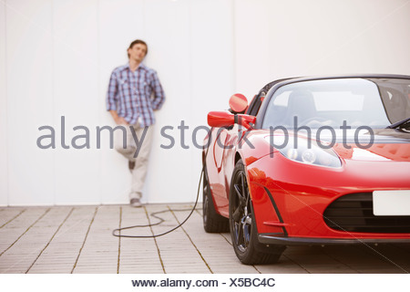 Young man filling up his electric car