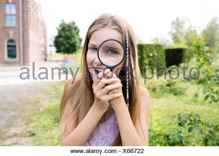 girl looking through magnifying glass x66722