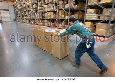 A Man Moving Recycling Boxes In A Clothing Distribution Center In