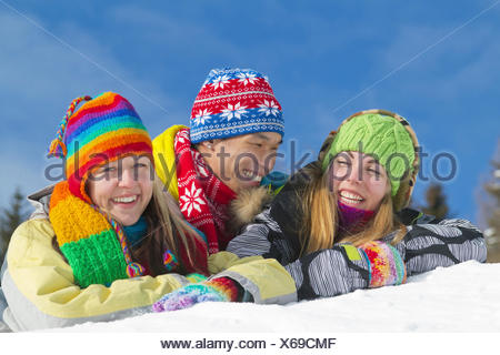 young-asian-man-and-two-young-european-women-smiling-while-lying-on-a-mound-of-snow-and-wearing-colourful-winter-clothing-x69cmf What Are the Most trusted Online Dating Sites?