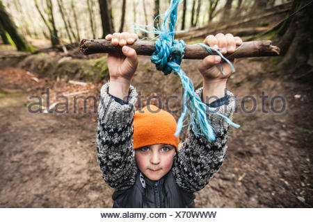 Boy hanging on a swing in a playground Stock Photo ...