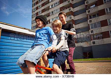 Boy giving two friends a ride on bike