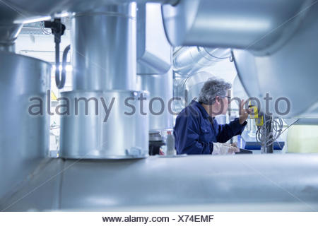 Engineer adjusting control panel in power station