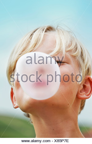 Smiling boy blowing bubble outdoors